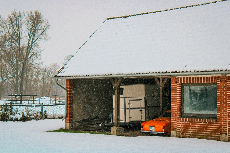 an orange car is out in the snow