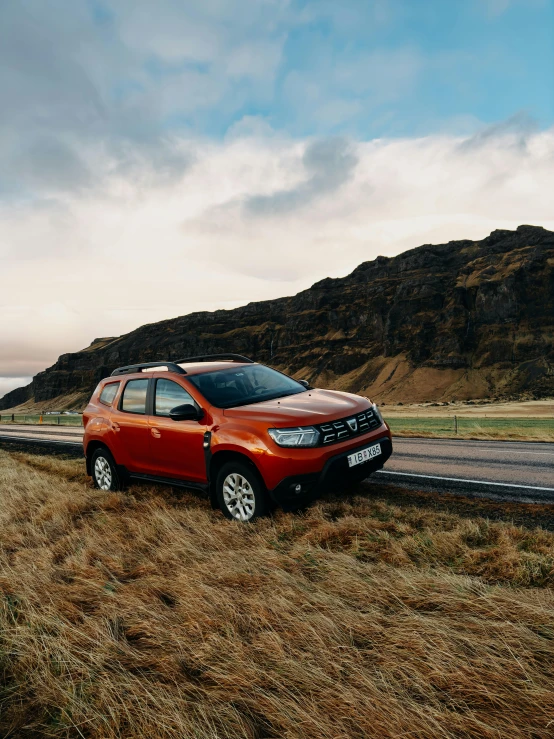 a red suv is driving down the road