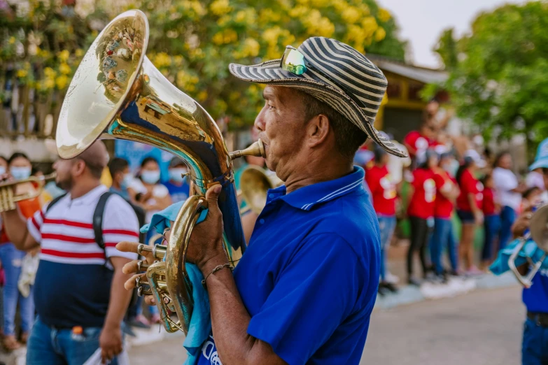 a man with a hat on holding a ss instrument