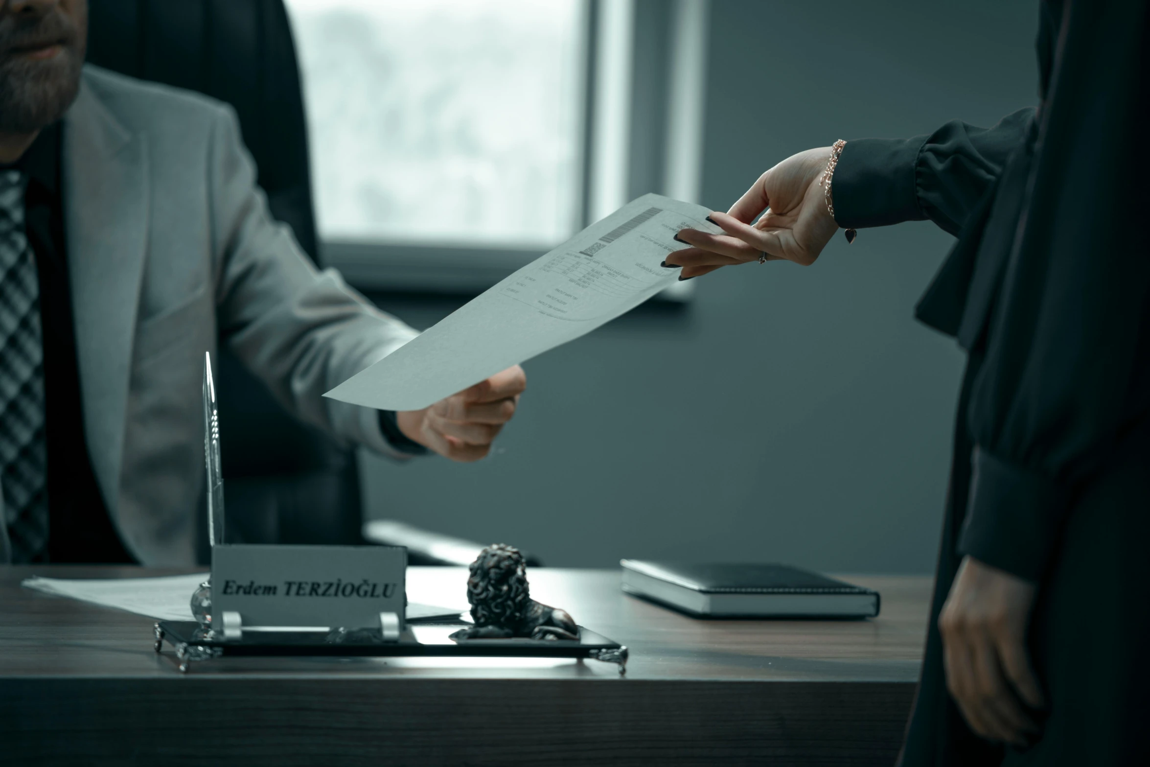 two people exchanging papers from one another