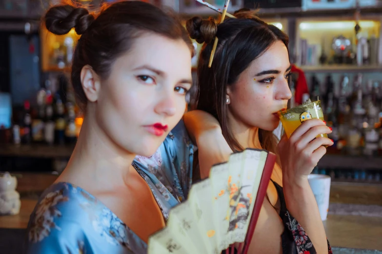 two women holding up soing next to each other