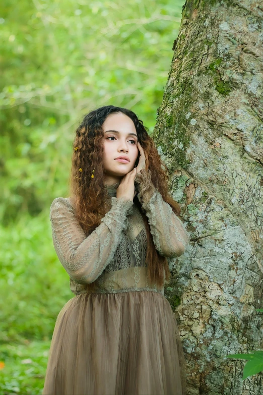 an image of a  posing in front of a tree