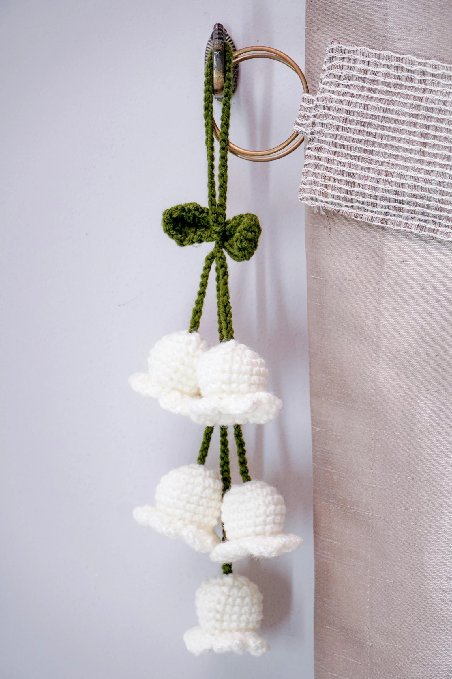 an item hanging on a hook, which includes three flowers