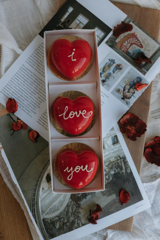 two hearts - shaped donuts with i love you in them on the table