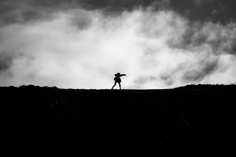 a person standing on a grass covered hill