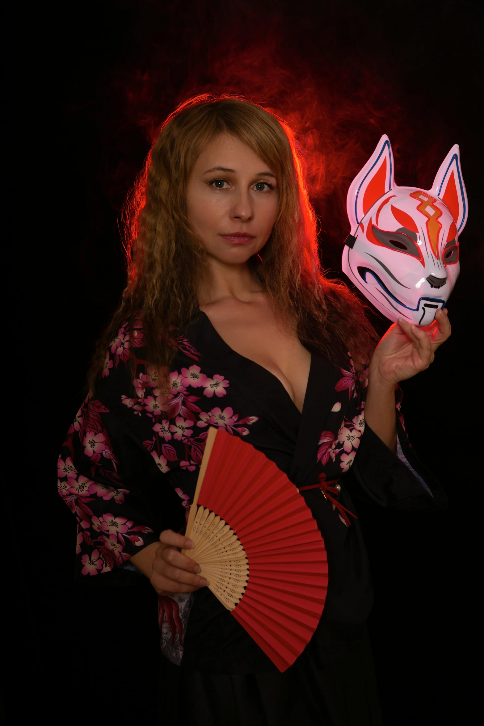 a woman is holding a red paper mask with a fox