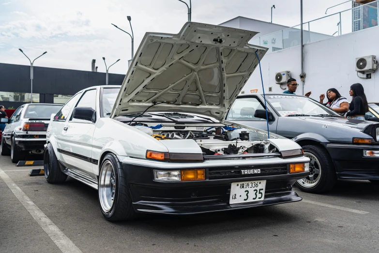 many cars in parking lot with open hood