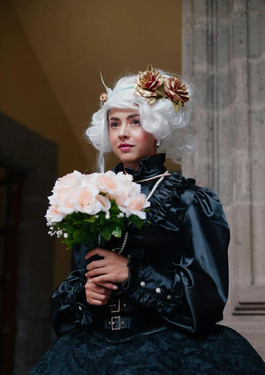 a person dressed up in a fancy outfit and holding a bunch of flowers