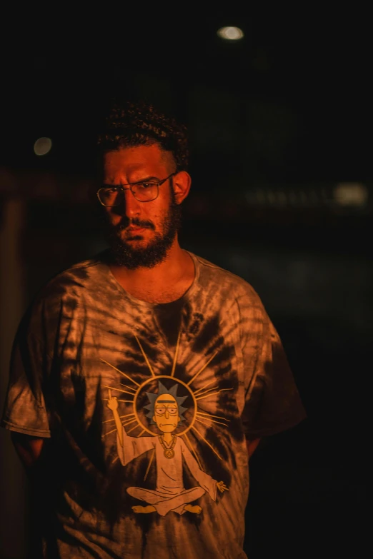 a man wearing a tie - dye shirt and glasses while holding a beer