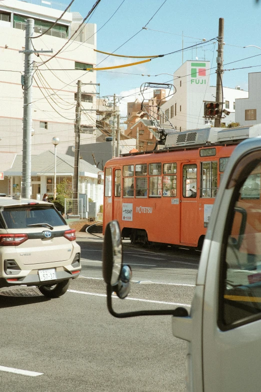 a trolley on the side of the road next to another car