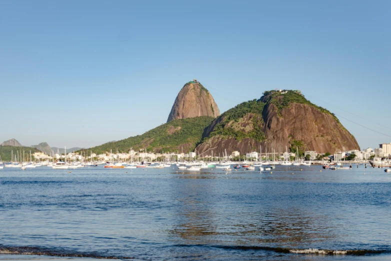 boats are moored in the harbor near a large mountain