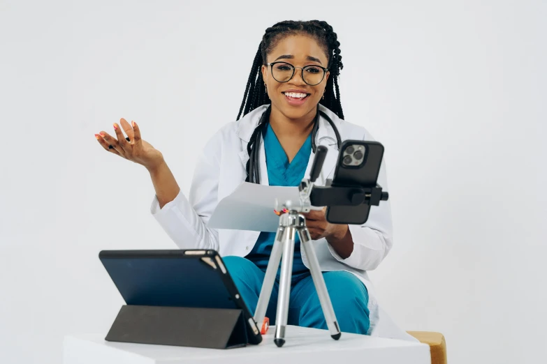 a woman in a doctor's uniform is holding her ipad