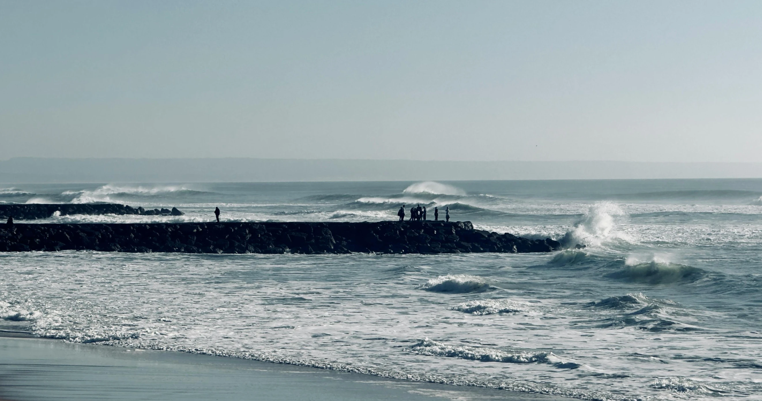 an empty beach next to a bunch of waves