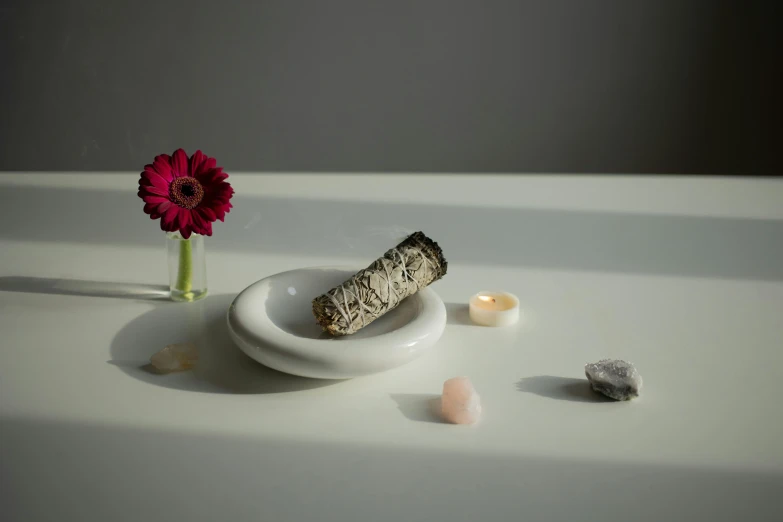 a small vase and a piece of wood sitting on a table