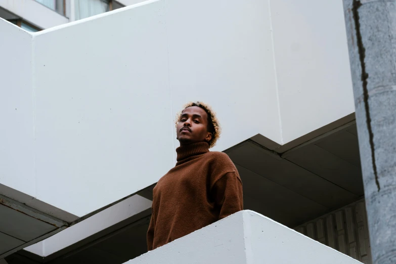 a young person standing at the bottom of an empty staircase