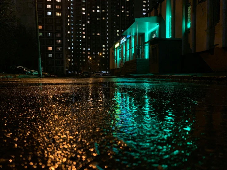 rain is shining in the middle of a street at night