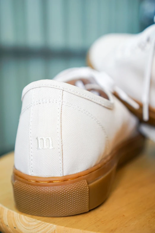 a wooden surface with white tennis shoes on top