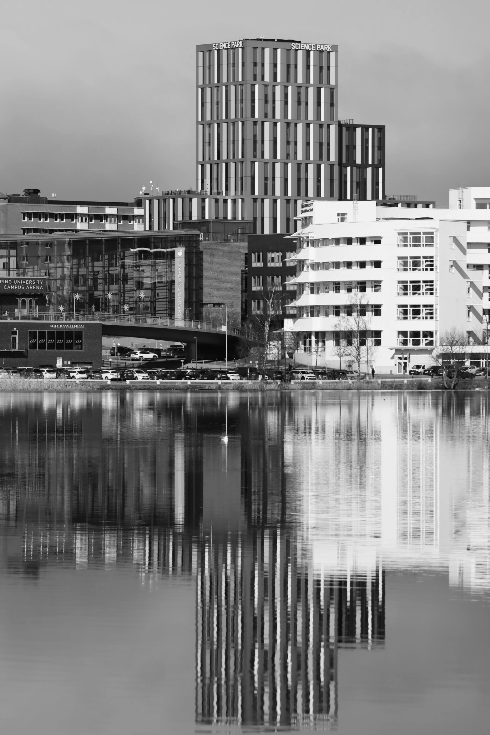 the modern buildings and other structures are reflecting in a still lake