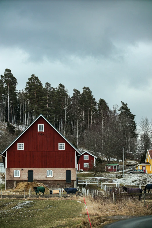 there is a red barn next to a fence