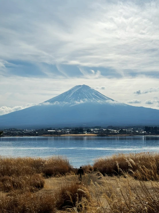 the clouds are hovering over a mountain on a lake