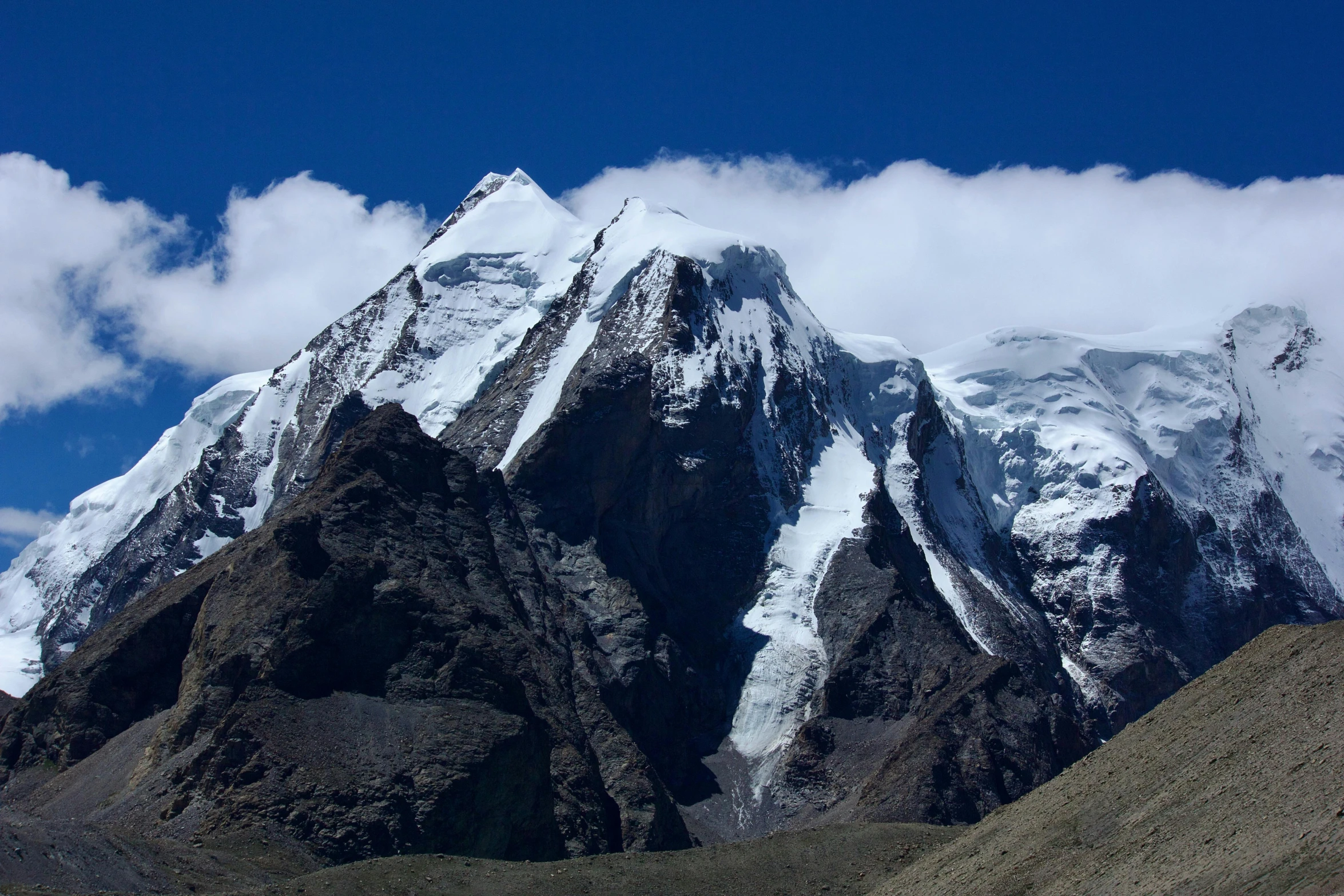 some mountains under a partly cloudy blue sky