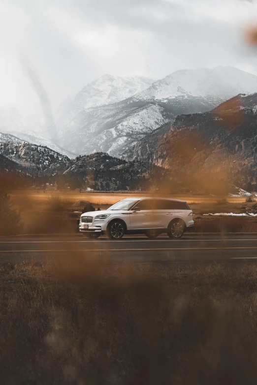 a car driving down a road by a mountain