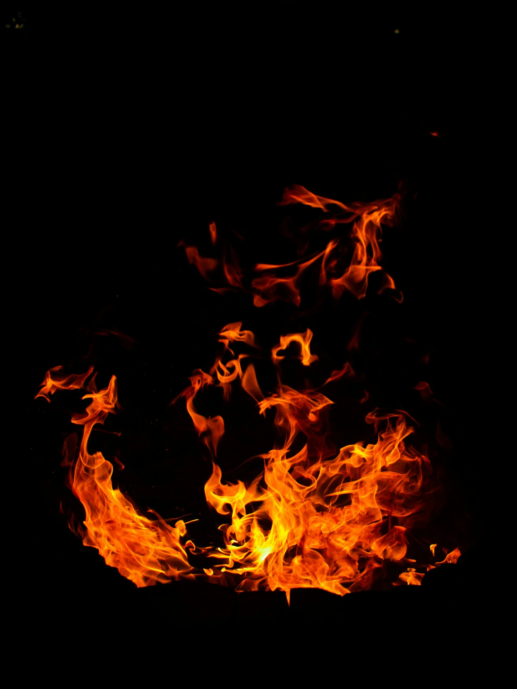 a fire in the dark with some yellow smoke coming out of it