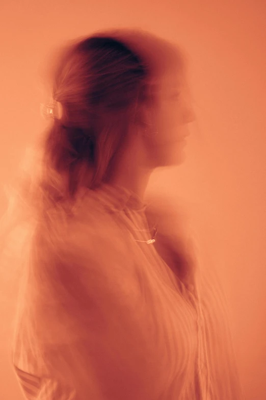 a woman standing in a red room with blurry hair