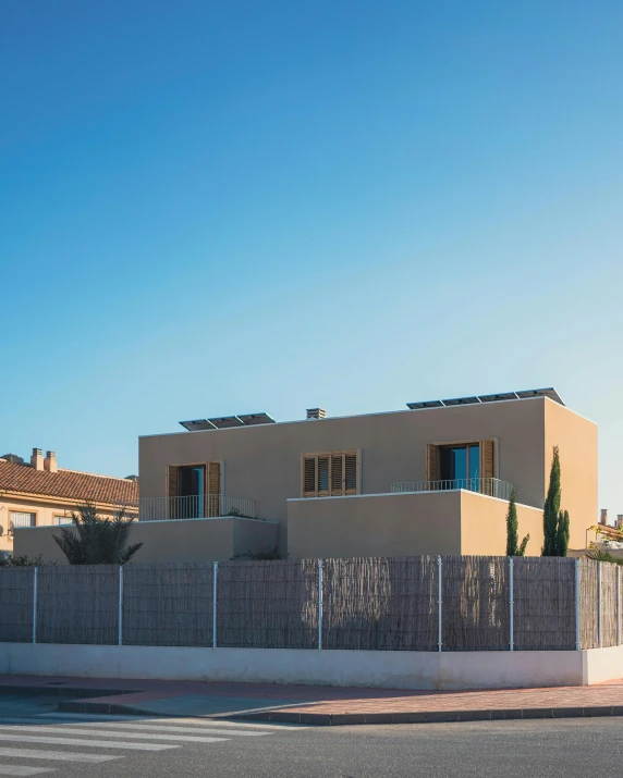 a house with brown fences and two car parked in front