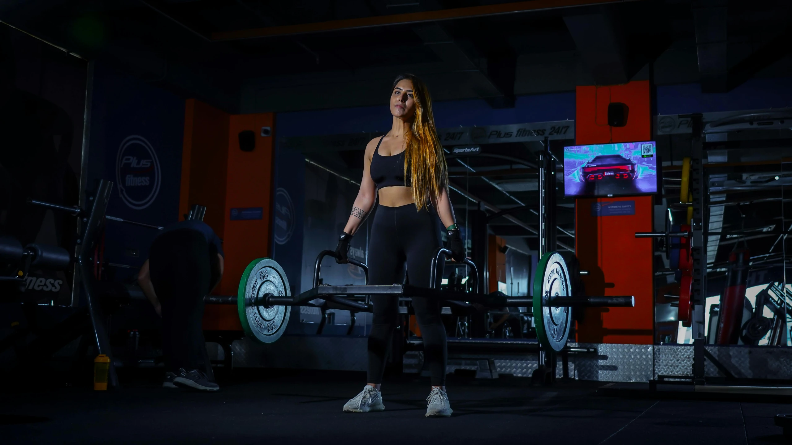 woman with long hair in a dark gymnasium with weights