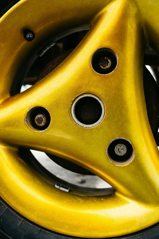 a yellow motorcycle wheel with black hubs on it