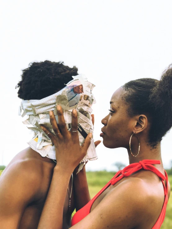 two women are kissing each other in a field