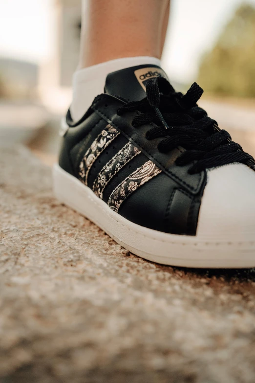 a woman's white and black adidas sneakers