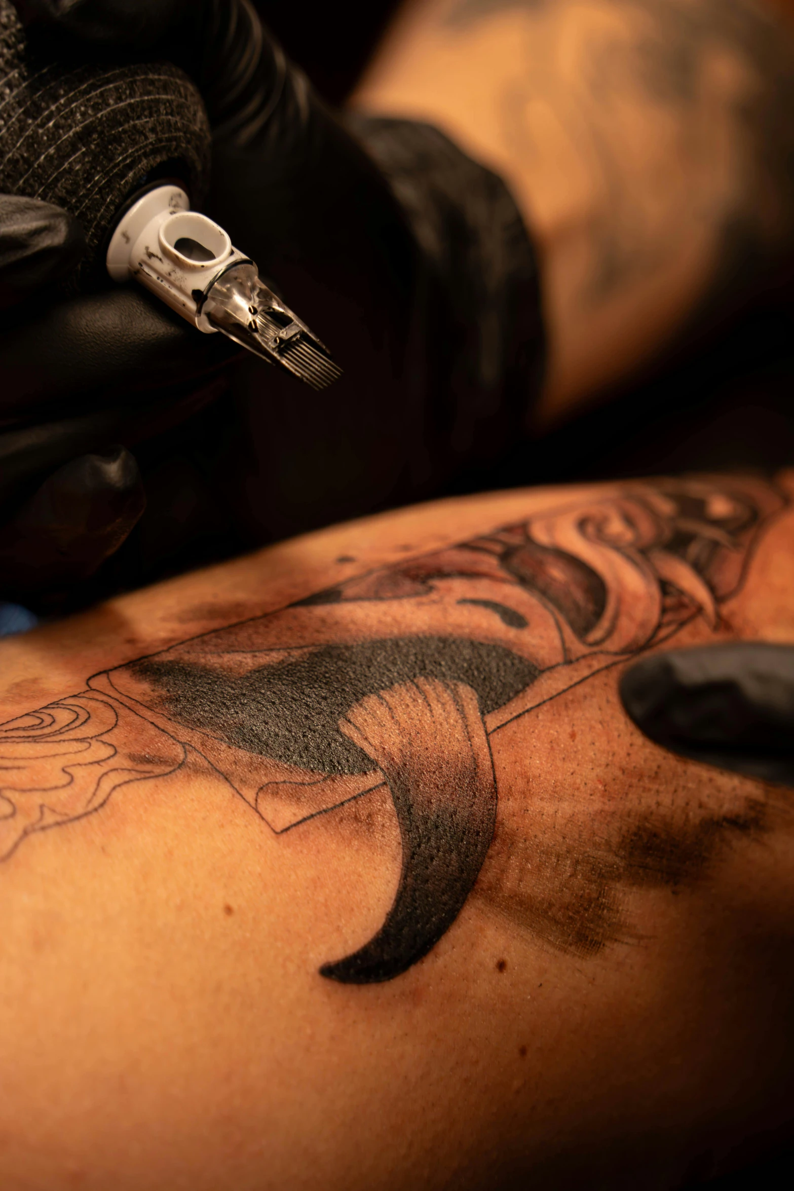 a tattoo artist doing a man's upper half with tattoos and ink