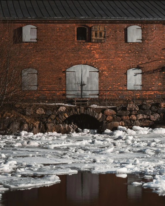 a red brick building is next to ice and water