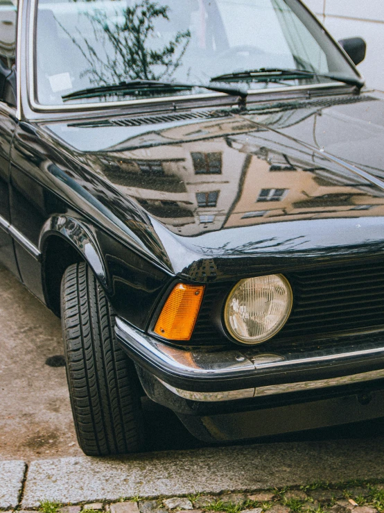 an old mercedes sits parked on the sidewalk