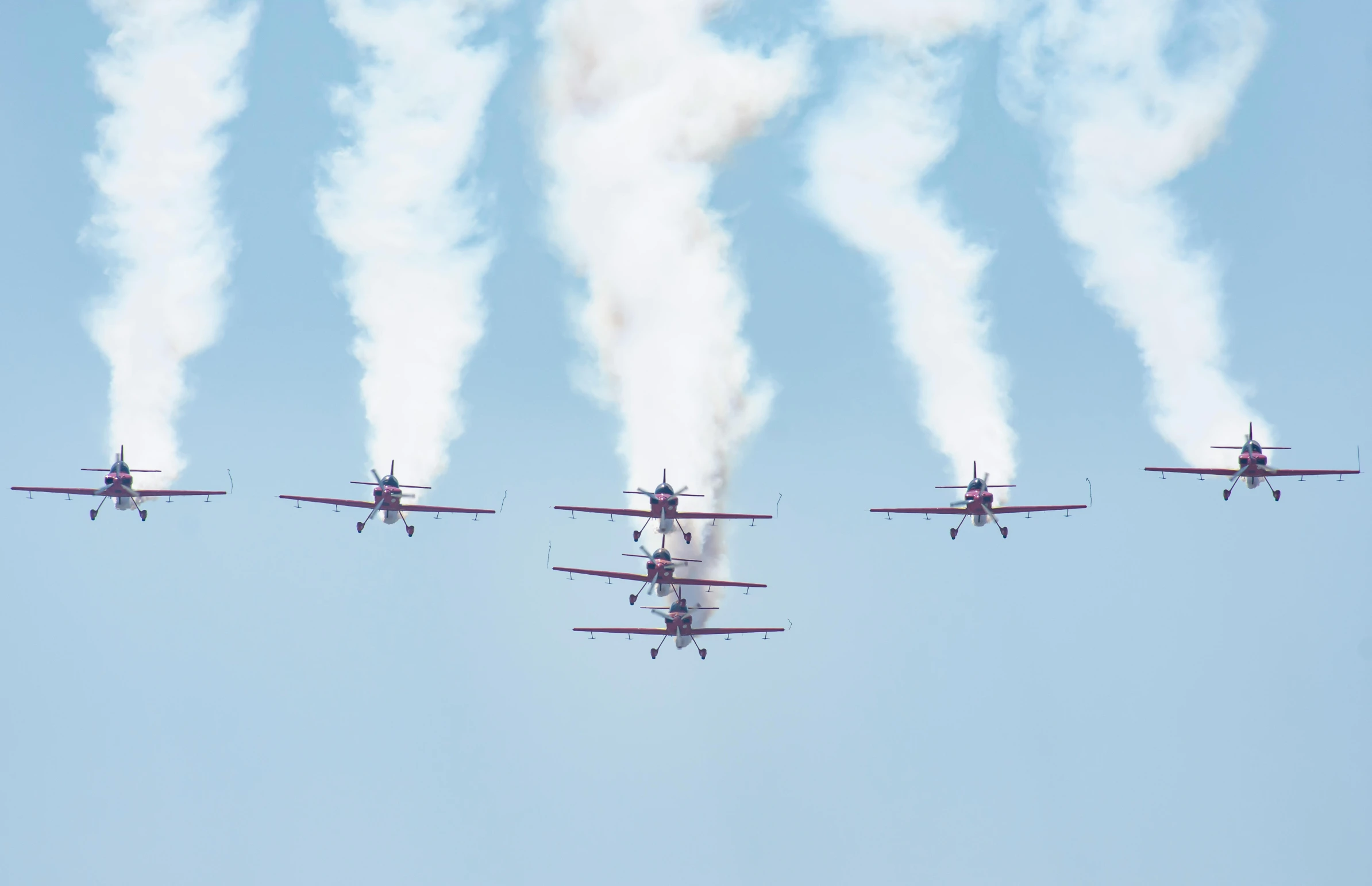 an formation of airplanes are flying in unison