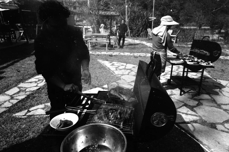 a woman is preparing food on an outdoor grill