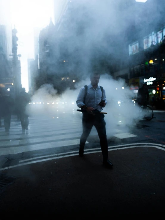 a man walking across a road covered in smoke