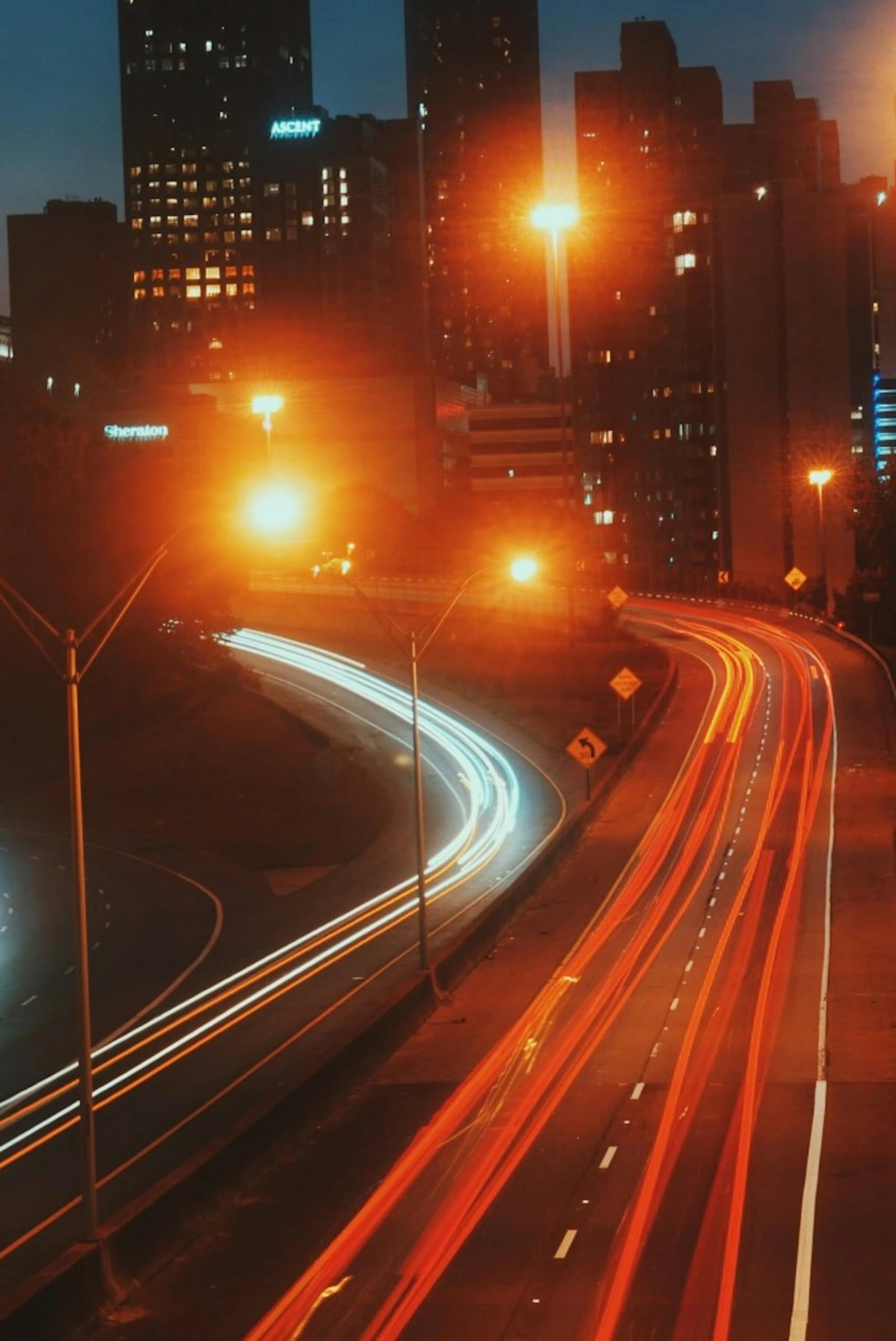 a city view with some traffic on the street at night