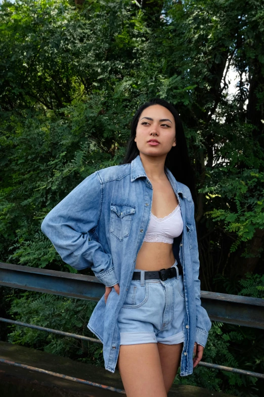 woman in a short jean jacket and  wearing denim shorts