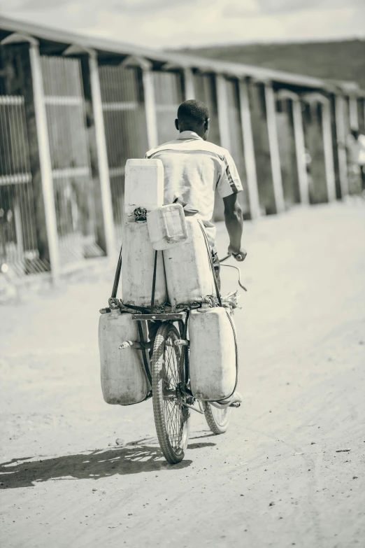 a man carrying several suitcases on his bicycle