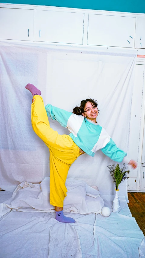 a woman posing in yellow pants with green shirt