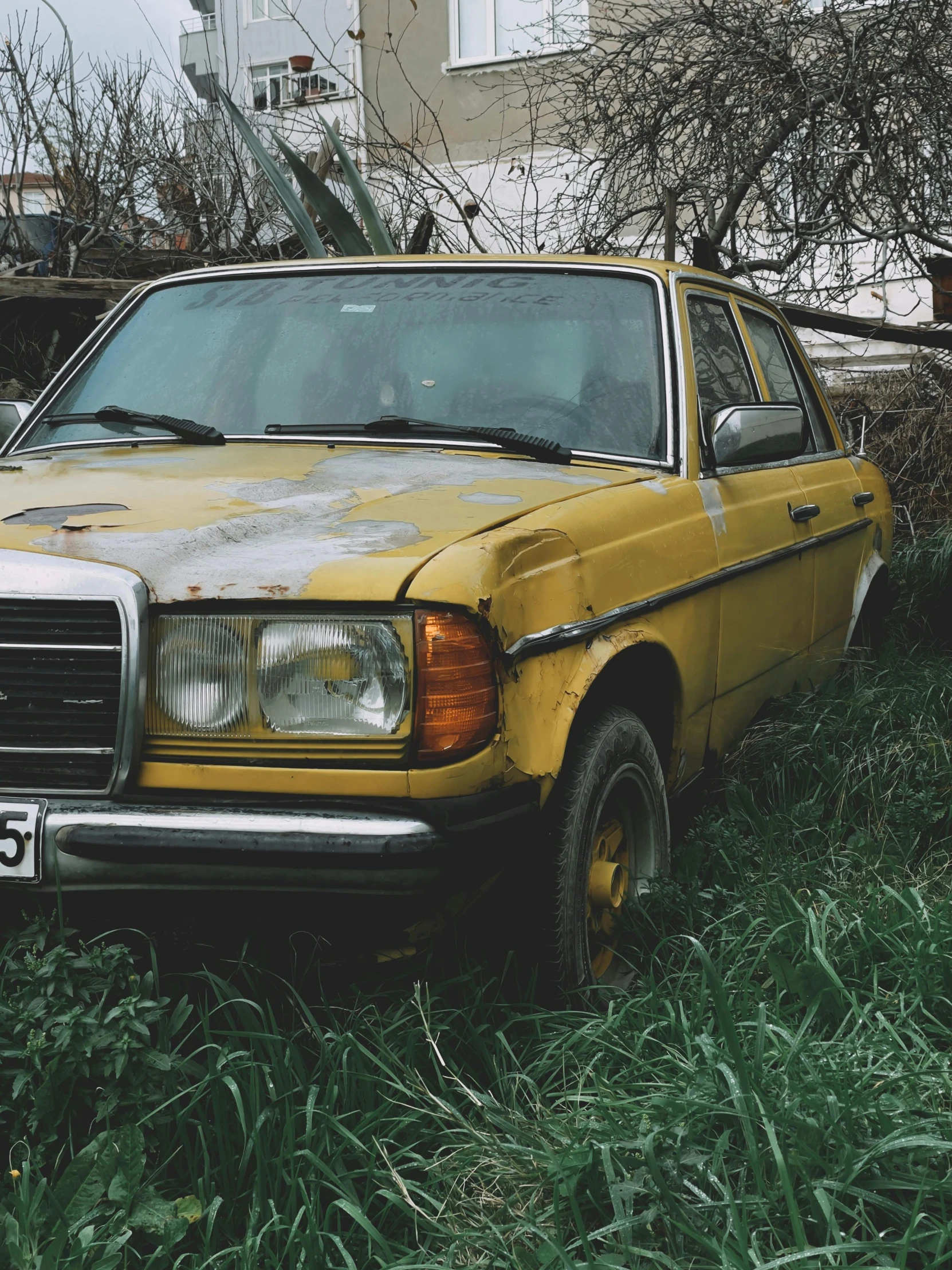 an old yellow truck parked in front of a house