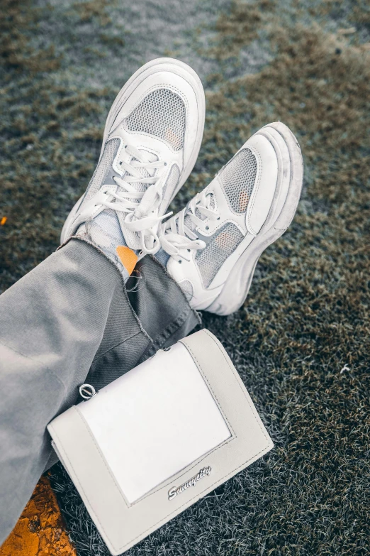 a book, tie, and sneakers are sitting on the ground