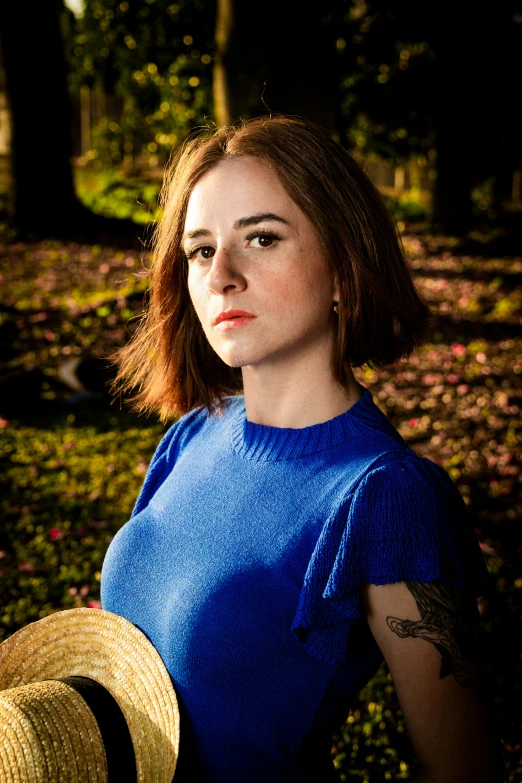 a young woman is wearing a blue shirt and a hat