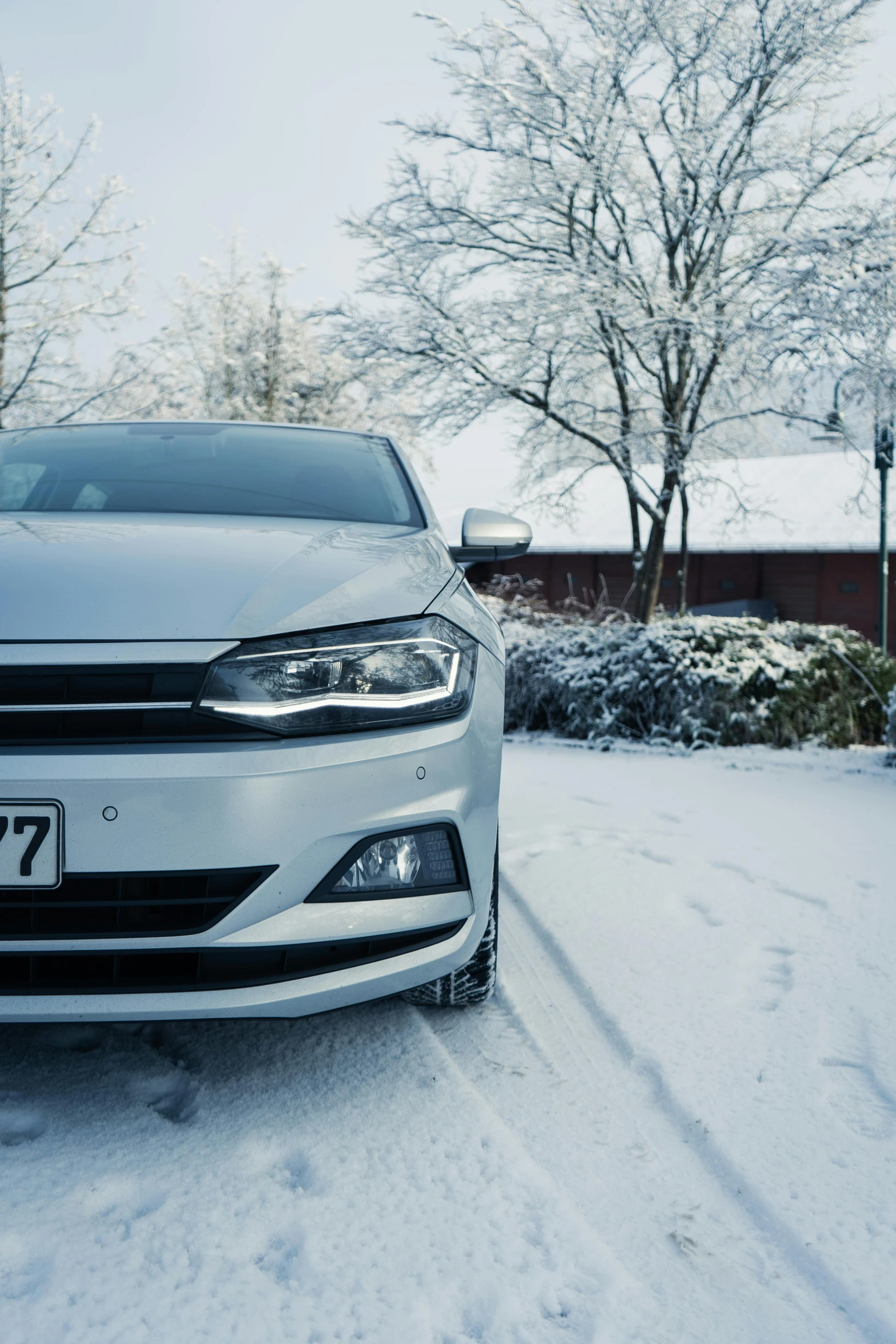 the front end of a car on a snow covered street