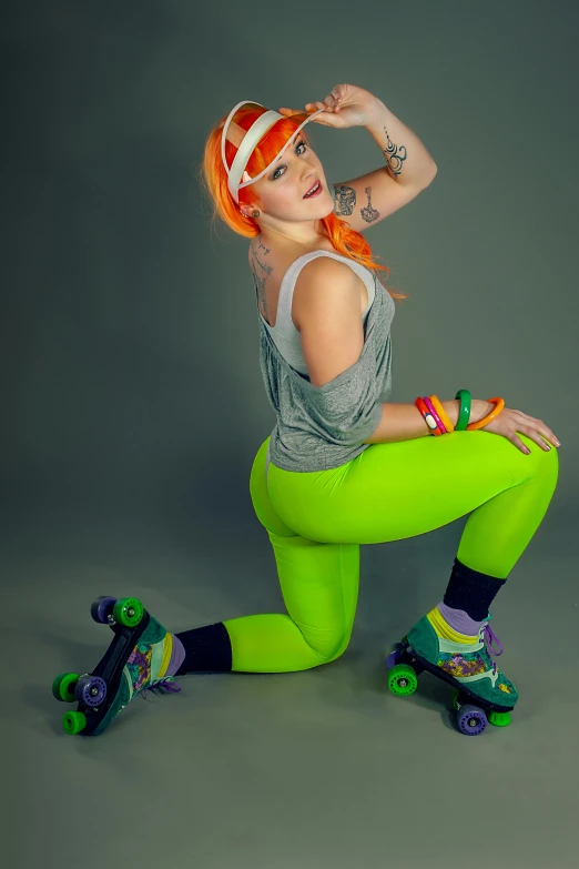 woman with red hair posing in grey tank top and green tights