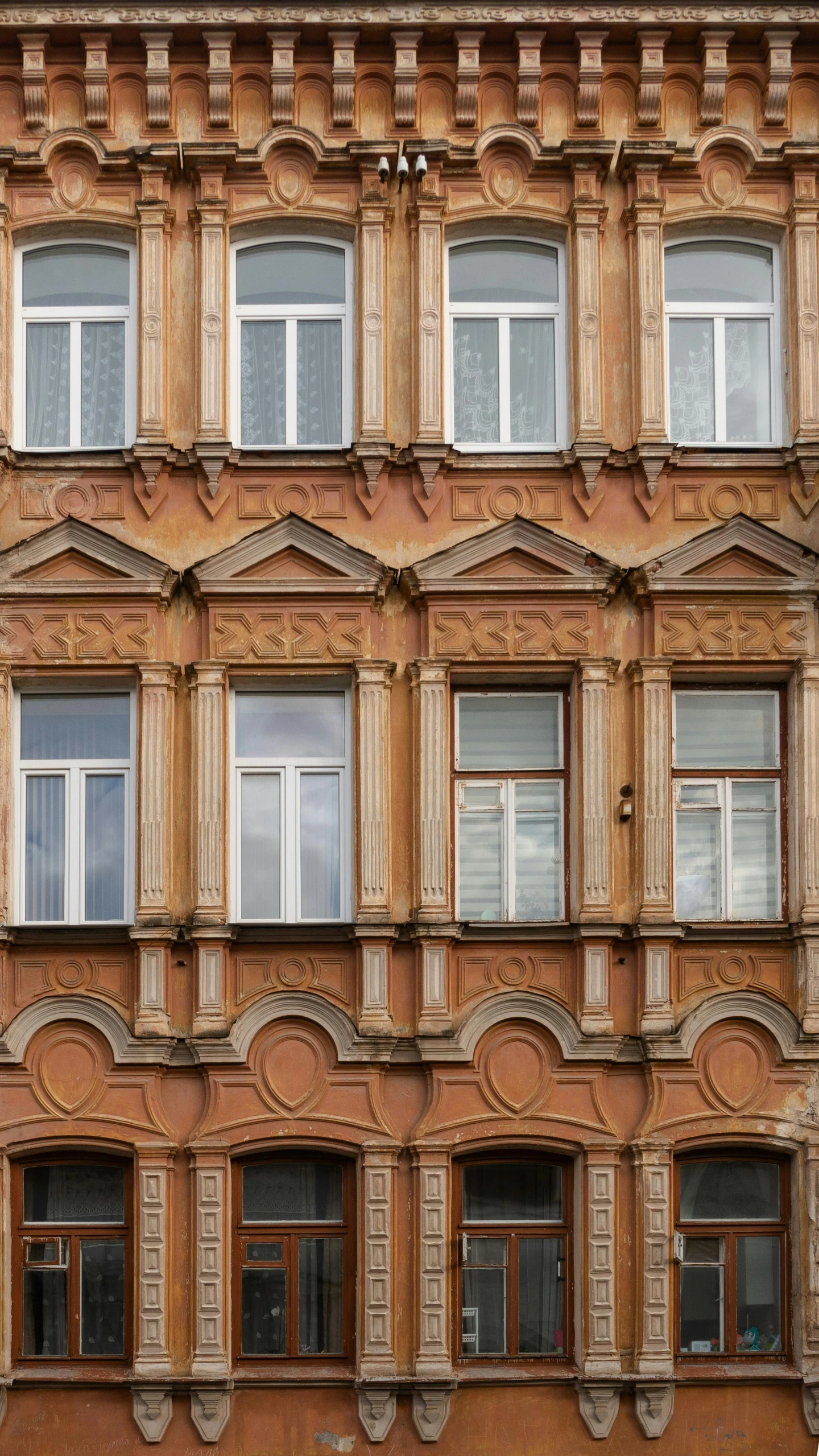 a building with lots of windows that have a clock on the front