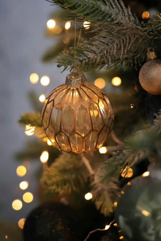 a large gold ball hanging from a christmas tree